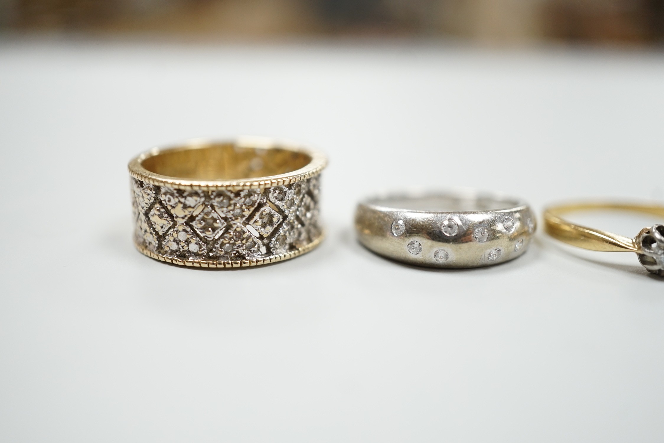 Three modern 9ct gold and diamond chip set rings and a yellow metal and solitaire diamond set ring, gross weight 12.4 grams.